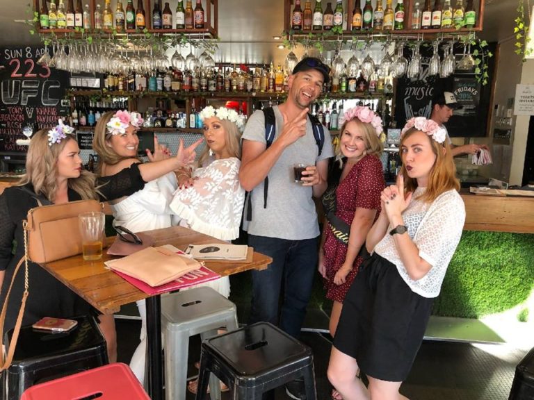 A group of hens in flower crowns having cheeky fun in a pub in Northbridge.